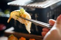 Aburi Engawa Sushi is clamped with metal chopsticks