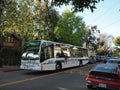 AC Transit bus with ads displayed on side driving down the street