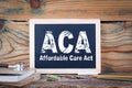 Aca, affordable care act. Chalkboard on a wooden background Royalty Free Stock Photo