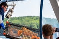 Acadia, Maine, USA - 8.2021 - Bar Harbor Wale Watch Company employee pulling a lobster pot on the boat.