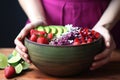 acai bowl being spritzed with lime by a hand