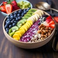 Acai bowl with strawberries, banana, blueberries, kiwi fruit, nuts and granola on wooden table. Nourishing breakfast full of Royalty Free Stock Photo