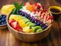 Acai bowl with strawberries, banana, blueberries, kiwi, mango and granola on wooden table. Nourishing breakfast full of vitamins,
