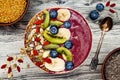 Acai breakfast superfoods smoothies bowl with chia seeds, bee pollen, goji berry toppings and fruits. Overhead. top view, flat lay