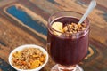 Acai in glass with muesli banana on wooden table