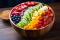Acai smoothie bowl with strawberry, banana, blueberries, kiwi, mango and granola on wooden table. Nourishing breakfast full of