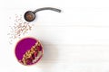 Acai smoothie, granola, seeds, fresh berries in a wooden bowl. Plate filled with berries and ceramic spoon on white