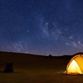 Camping tent in open field. Camp overnight. Camping tent with light on at night