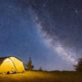 Camping tent in open field. Camp overnight. Camping tent with light on at night