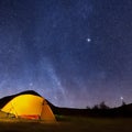 Camping tent in open field. Camp overnight. Camping tent with light on at night