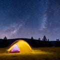 Camping tent in open field. Camp overnight. Camping tent with light on at night