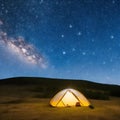 Camping tent in open field. Camp overnight. Camping tent with light on at night