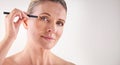 Accentuating her eyes with some eyeliner. Cropped studio shot of a mature woman applying eyeliner. Royalty Free Stock Photo