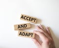 Accept or adapt symbol. Wooden blocks with words Accept and adapt. Beautiful white background. Businessman hand. Business and Royalty Free Stock Photo