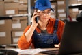 Accepting orders online. Internet shop worker accepting customer requests using a smartphone and laptop