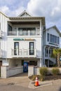 Access 16 Beach Shop at Johnnie Mercer\'s Fishing Pier with palm trees, an orange cone, light posts, blue sky and clouds