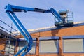 Access platform equipment powered high in sky at construction building site Royalty Free Stock Photo