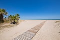 Access to beach in Castellon with palms and wooden footway Royalty Free Stock Photo