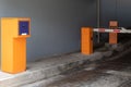 Entrance to chargeable parking space with turnpike and orange and charge machine Royalty Free Stock Photo