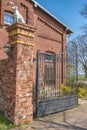 Access to an old farm. The facade and the walls of the enclosure are made of brick. Royalty Free Stock Photo