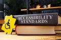 Accessibility standards book and disabled person sign.