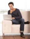 Accessing the internet from home. Portrait of a handsome young man using his laptop at home. Royalty Free Stock Photo