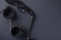 Accessories for bdsm on a black background. Leather lash and leather handcuffs. Valentine`s Day. Erotic shop. Copy space