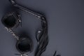 Accessories for bdsm on a black background. Leather lash and leather handcuffs. Valentine`s Day. Erotic shop. Copy space