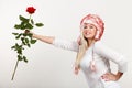 Woman in winter furry hat holding red rose