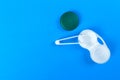 Accessories for contact lenses: container, tweezers. Blue background Royalty Free Stock Photo