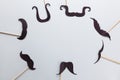 Accessories in form of black moustache on sticks on grey background with place for text. Concept movember, men`s health, prostate