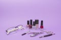 Accessories manicure and glasses for vision on purple background