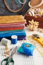 Accessories for quilting and a stack of colorful fabrics for quilting on the background of the box with seashells Royalty Free Stock Photo