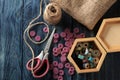 Accessories for sewing and needlework. a casket with bobbins, buttons, scissors and burlap on a dark blue wooden background. Royalty Free Stock Photo