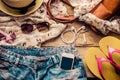 Accessories for teenage girl on her vacation, hat, stylish for summer sunglasses, leather bag, shoes and costume on wooden floor. Royalty Free Stock Photo