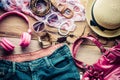Accessories for teenage girl on her vacation, hat, stylish for summer sunglasses, leather bag, shoes and costume on wooden floor Royalty Free Stock Photo