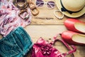 Accessories for teenage girl on her vacation, hat, stylish for summer sunglasses, leather bag, shoes and costume on wooden floor Royalty Free Stock Photo