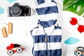 Accessories for treveling with children, camera and suit on white background top view