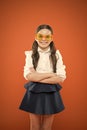 Accessory far too stylish to take off. Small kid smiling in fancy accessory on orange background. Happy girl wearing eye Royalty Free Stock Photo