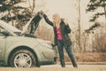 Blonde woman and broken down car on road Royalty Free Stock Photo