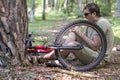 An accident while cycling. Man having trouble feeling knee pain after falling off the bike in a forest. Royalty Free Stock Photo