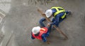 accident in site work,a piece of wood fell from height hit on a worker's legs while working at a new building