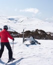 An accident on skis, female skier in the foreground trying to help another skier in Charlotte& x27;s Pass ski resort in Australia