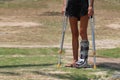 Accident tourist girl are walking by crutches in the garden. Royalty Free Stock Photo