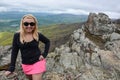 Accomplished smiling blonde woman hiker poses at the summit of LIttle Stony Man, a hike in Shenandoah National Park in Virginia on