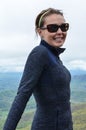 Accomplished smiling woman hiker poses at the summit of LIttle Stony Man, a hike in Shenandoah National Park in Virginia on a