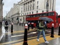 Rainy day in London city centre with people and umbrellas, England 2021