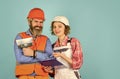 According to plan. Discussing renovation with contractor. Plastering works. Couple look documents. Woman and man safety Royalty Free Stock Photo