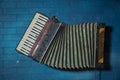 Accordion front side view. musical instrument . old vintage garmon, harmonic on blue wall background Royalty Free Stock Photo