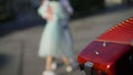 An accordionist is playing outside, and a young couple is dancing. The accordion is in focus, and the dancing couple is out of